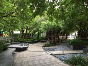 a park with trees and a wooden walkway with benches at HIGH RISE LUXURY CONDO 1BED ROOF TOP POOL 2 MinMRT in Bangkok