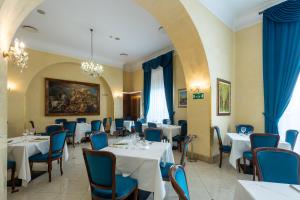 restauracja z białymi stołami i niebieskimi krzesłami w obiekcie Hotel Centrale Spa & Relax w mieście Alcamo