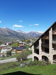 vistas a un edificio con montañas en el fondo en Les Campanules, en Saint-Léger-les-Mélèzes