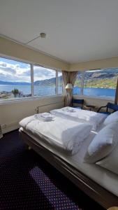 ein großes Bett in einem Zimmer mit großen Fenstern in der Unterkunft Sognefjord Hotel in Hermansverk