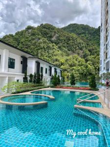 a swimming pool in front of a building with a mountain at Sunway Onsen Hotsprings with Ipoh City View, Sunway Lost World in Ipoh