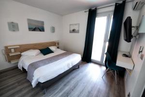 a bedroom with a bed and a large window at Hotel Aquarius in Canet-en-Roussillon