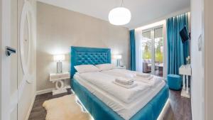 グダニスクにあるApartamenty Sun & Snow Jelitkowskaの青いベッドルーム(大型ベッド1台、青いヘッドボード付)
