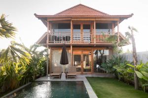 a villa with a pool and a house at Bruann residence villa 2 Seseh Perenenan amazing views in Munggu