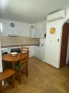 cocina con mesa de madera y mesa pequeña con sillas en Apartamento n35 - Oasis Park II en Denia