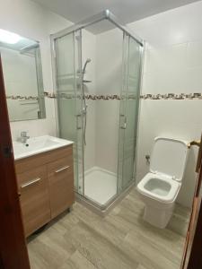 y baño con ducha, aseo y lavamanos. en Apartamento n35 - Oasis Park II en Denia