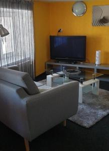 ein Wohnzimmer mit einem Sofa und einem TV in der Unterkunft Penzion Miromar in Podivín