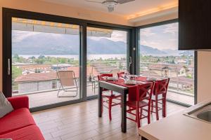 comedor con mesa y sillas y ventana grande en BELLA VITA Residence, en Gravedona