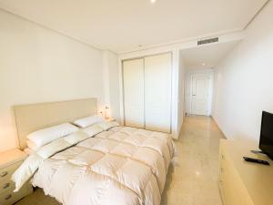 ein Schlafzimmer mit einem großen Bett und einem TV in der Unterkunft Oasis Beach III in Altea la Vieja