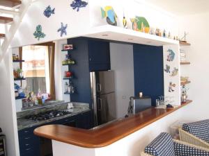 a kitchen with a counter and a refrigerator at Villa mit Whirlpool und phantastischer Aussicht in Capoliveri