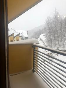 a view of a snow covered view from a balcony at Mavrovo residence, 5 min walk to ski area in Mavrovo