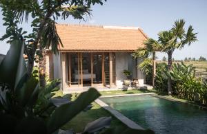 a house with a swimming pool in front of it at Bruann residence villa 2 Seseh Perenenan amazing views in Munggu