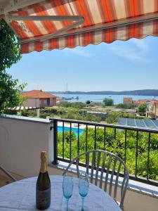 una mesa con 2 copas de vino en el balcón en Apartments Zulim, en Trogir