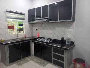 a kitchen with black counter tops and a sink at Yaths homestay in Butterworth