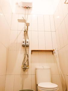 baño con aseo y una luz en la pared en SleepHouse 2BR Cozy Place for StayCation, en Cirebon