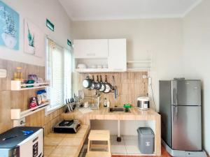 a small kitchen with a stainless steel refrigerator at SleepHouse 2BR Cozy Place for StayCation in Cirebon