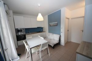 a small kitchen with a white table and chairs at Residence Verdena appartamento 02 in Rosolina Mare