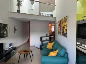 a living room with a blue couch and a tv at Loft LUMINOSO San Juan in Telde