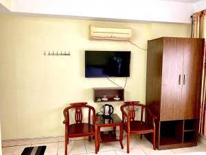 a room with two chairs and a table and a tv at Hotel Kien Nga in Thach Loi