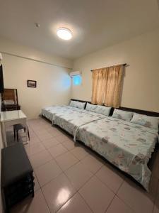 - une chambre avec un lit et un bureau dans l'établissement Sin Yu Guest House, à Green Island