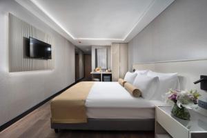 a bedroom with a large bed with a tv on a wall at Pianoforte by Febor Hotels&Spa in Istanbul