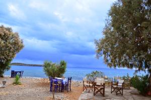 a group of tables and chairs on the beach at Georgoshouse Lykos beach Sfakia in Livanianá