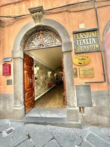 una entrada a un edificio con un cartel en él en PENSIONE ITALIA en Bolsena