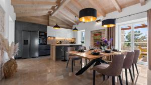 una cucina e una sala da pranzo con tavolo e sedie in legno di Villa Iria Bella a Marčana