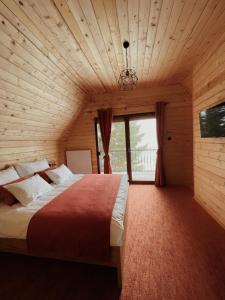una camera da letto con un grande letto in una camera in legno di Planinska kuća Dunja a Jahorina