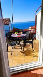 un patio con tavolo e sedie sul balcone. di Apartment Anita a Trogir