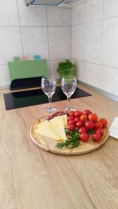 a plate of cheese and wine glasses on a table at Apartment Anita in Trogir