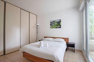 - une chambre avec un grand lit blanc et une fenêtre dans l'établissement L'Odyssée, Appt 4 pers, parking privé, Wifi, à Montpellier