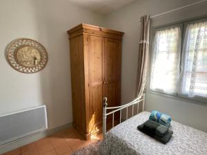 - une chambre avec un lit et une armoire en bois dans l'établissement La Petite Auberge - Gîtes, à Razac-dʼEymet