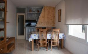 una sala da pranzo con tavolo, sedie e televisione di Ca la Estrella I l'Estartit a L'Estartit