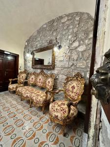 a living room with couches and a stone wall at PENSIONE ITALIA in Bolsena