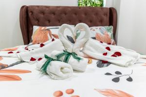 two swans towels on a bed with flowers at Mount Austin Midori Green 10 Pax Free Wi-Fi 500Mbps Netflix in Johor Bahru