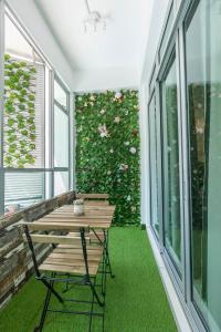 a porch with a wooden table and a plant at Mount Austin Midori Green 10 Pax Free Wi-Fi 500Mbps Netflix in Johor Bahru
