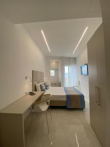 Schlafzimmer mit einem Bett, einem Schreibtisch und einem Computer in der Unterkunft Hotel Lucia in Castellammare di Stabia