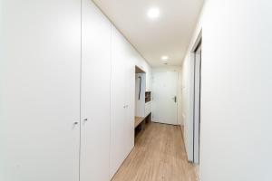 a hallway with white walls and wood floors at Apartments Harfa in Prague