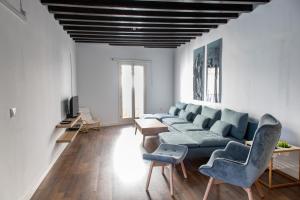 a living room with a blue couch and two chairs at Diana de Columela by Cadiz Time in Cádiz