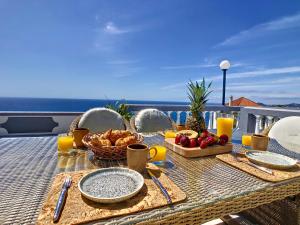a table with food on top of a balcony at Avocado Villa by LovelyStay in Funchal