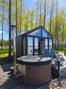 a tiny house with a hot tub and a gazebo at Paplūdimio namukas in Molėtai