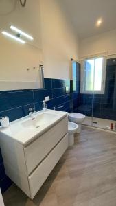 ein Badezimmer mit einem weißen Waschbecken und einem WC in der Unterkunft Villa Corallo - Scopello Guidaloca Bay in Scopello