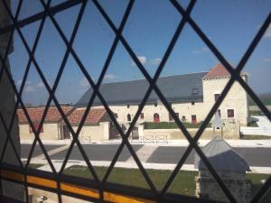 uma vista de uma igreja através de uma janela em Gîte Brilhac em Monts-sur-Guesnes