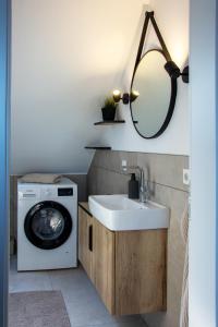 ein Badezimmer mit einer Waschmaschine und einem Waschbecken in der Unterkunft Knipper RE24 in Sögel