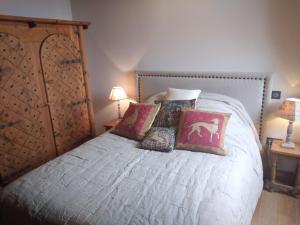 a bedroom with a large bed with pillows on it at Gîte Brilhac in Monts-sur-Guesnes