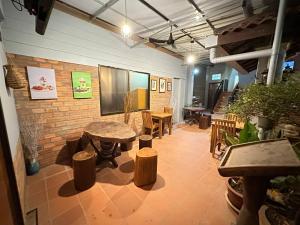 a room with a table and chairs and a brick wall at Nika's House in Siem Reap