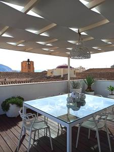 un tavolo su una terrazza con sedie e soffitto di Attico San Domenico a Trapani