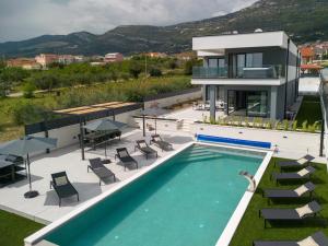 a villa with a swimming pool and a house at Villa Duje in Kastel Stari