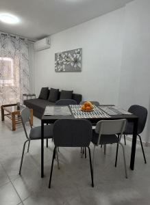 a dining room with a table and chairs and a couch at Marina Apartments - Valentin in Santa Pola